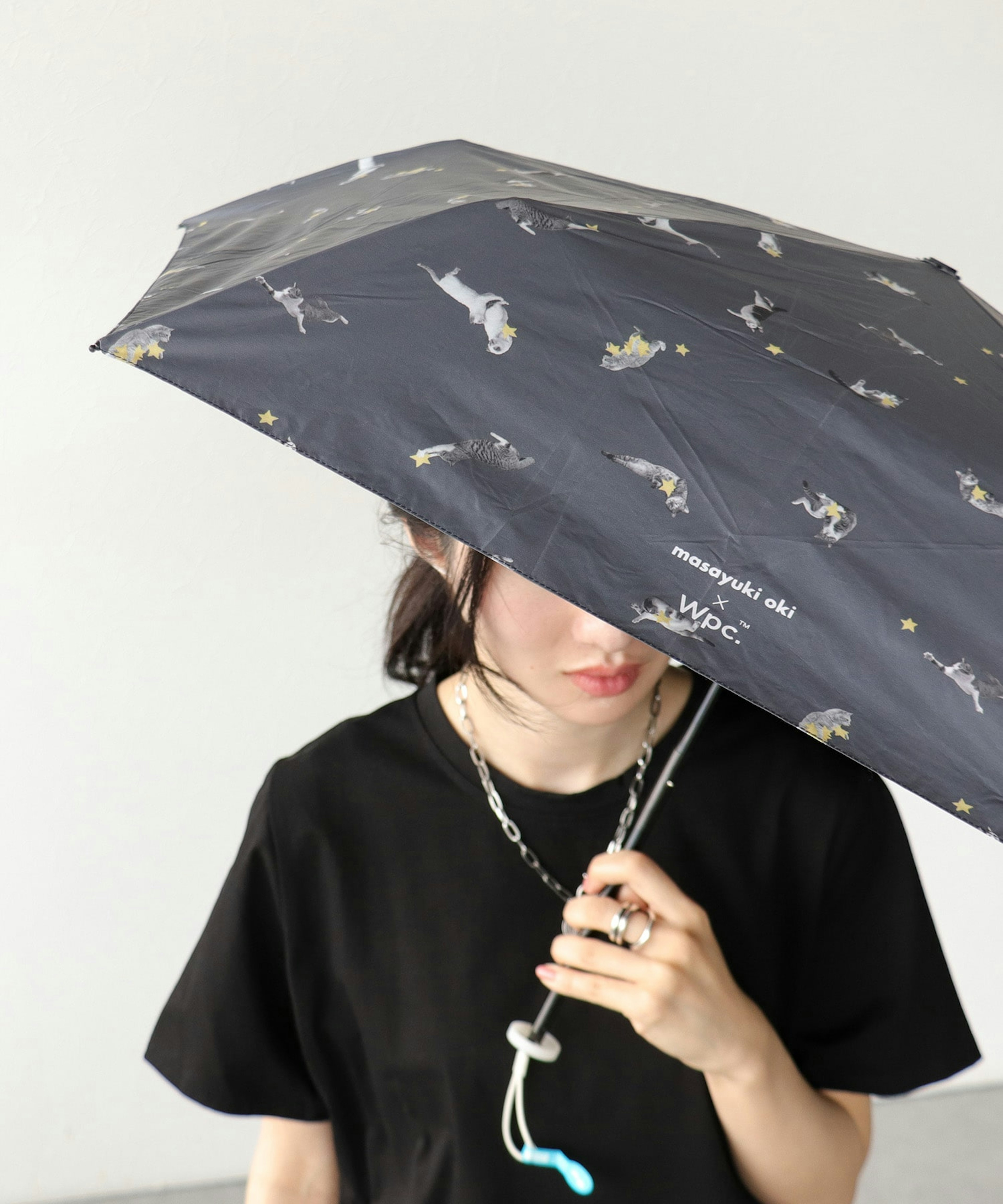 ネコちゃん柄の黒い日傘をさしている女性