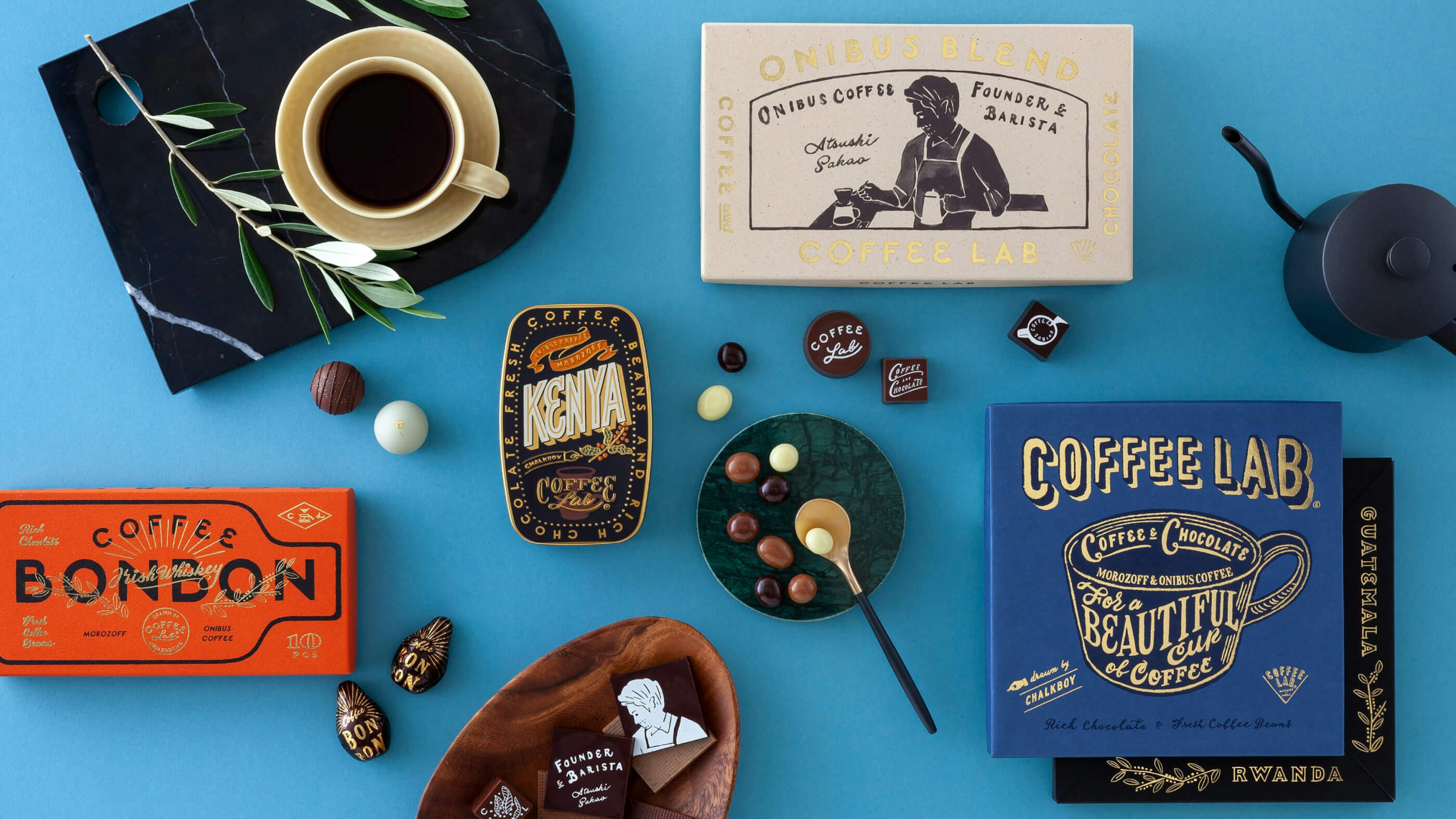 オニバスコーヒーとモロゾフのチョコレートCOFFEE LABが青い背景の上に並んでいる。箱にはおしゃれなイラスト入り。