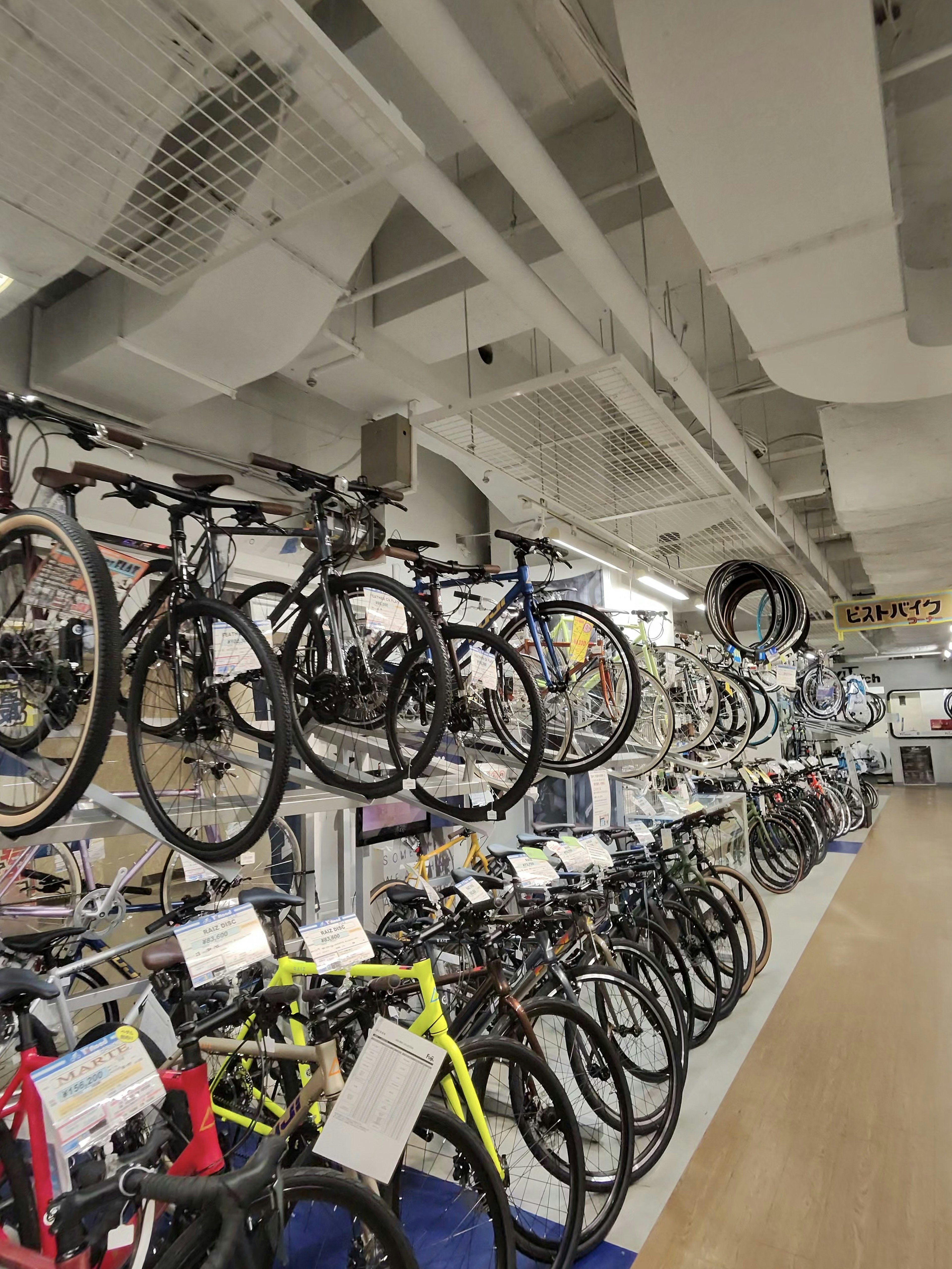 様々なモデルの自転車が展示されている店内、天井にはタイヤが吊るされている