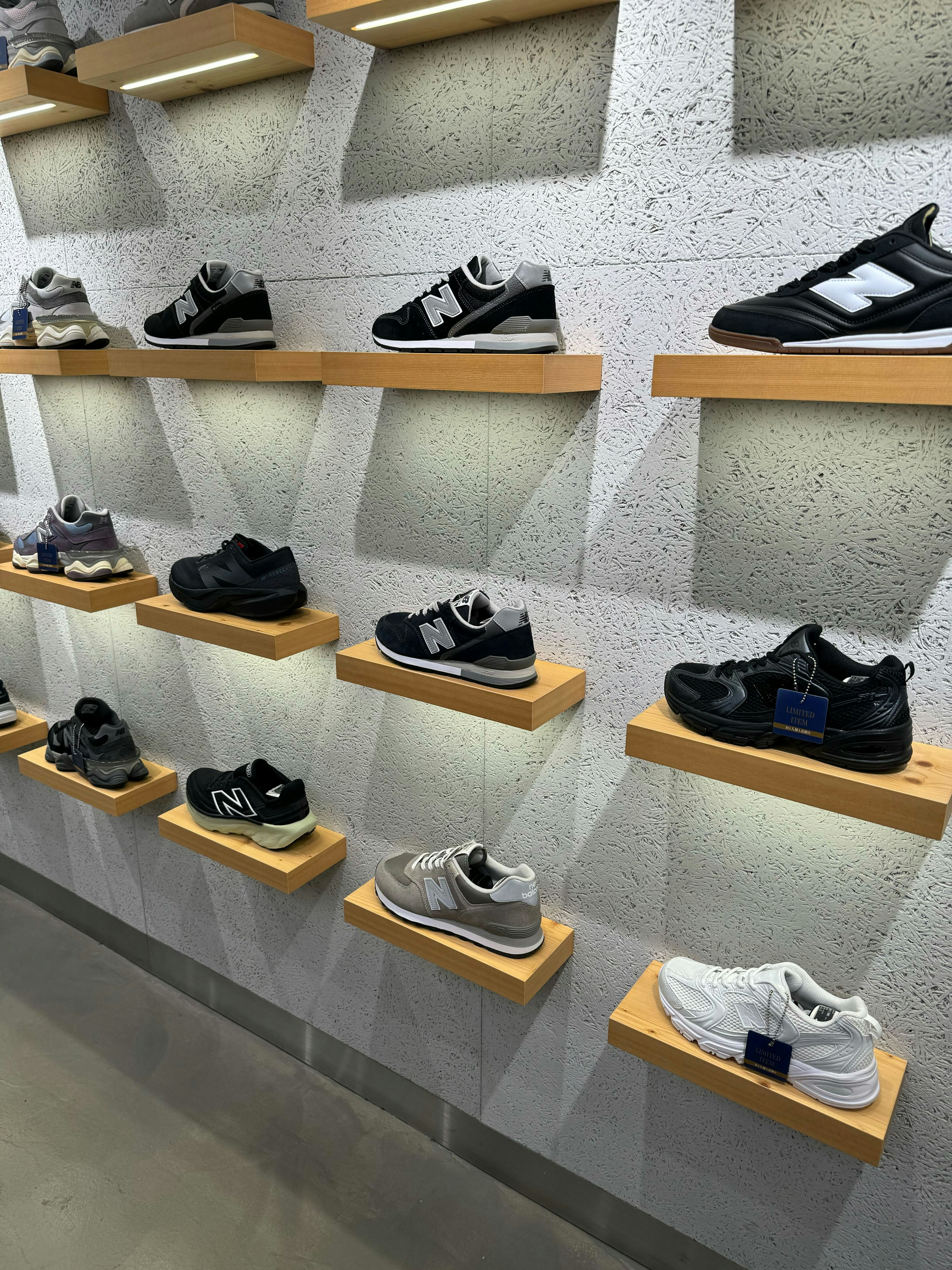 ニューバランスニュウマン新宿店の壁棚に陳列されたさまざまなスニーカー