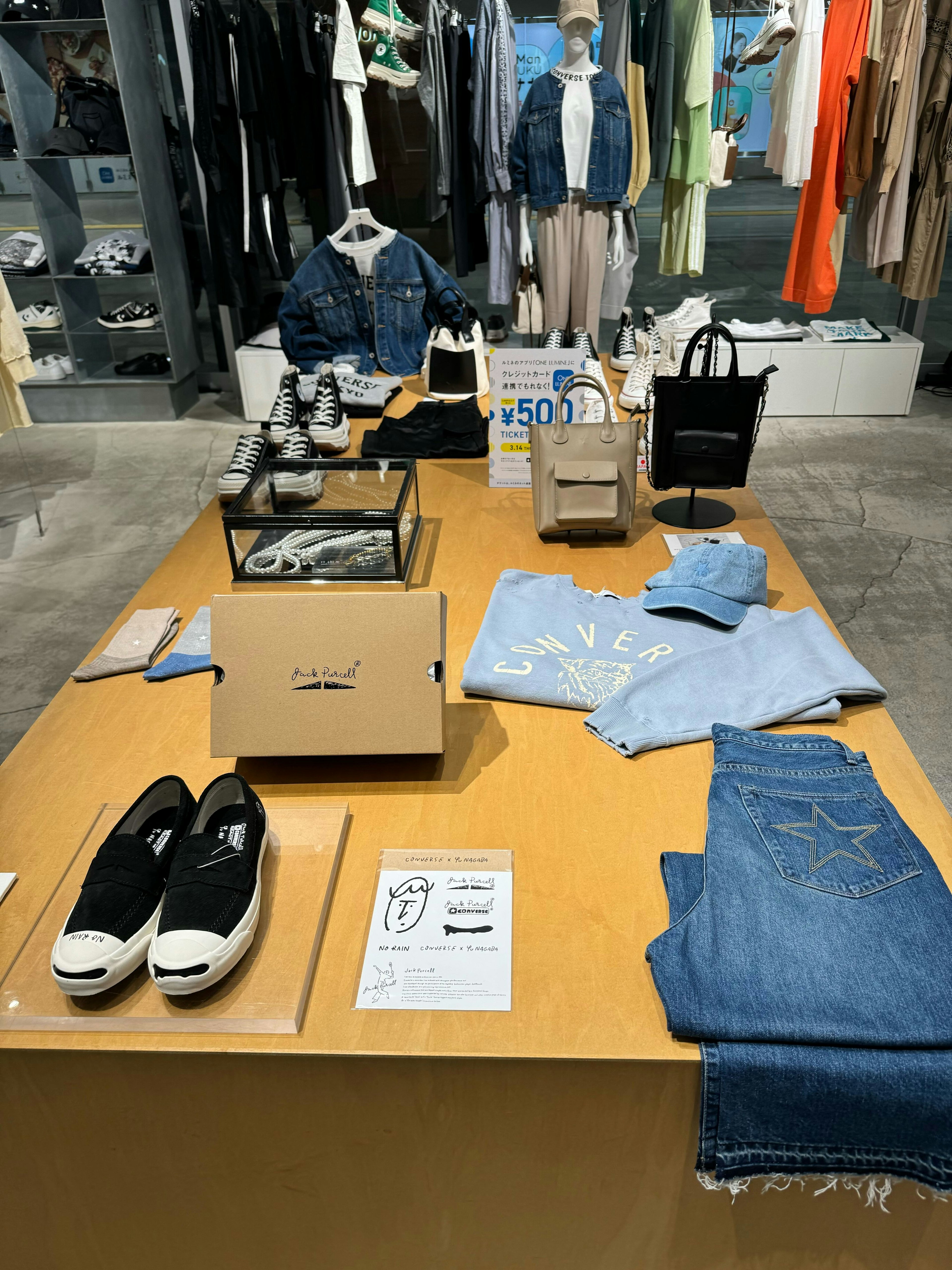 ディスプレイテーブルにコンバースの靴とファッションアイテムが展示されています。