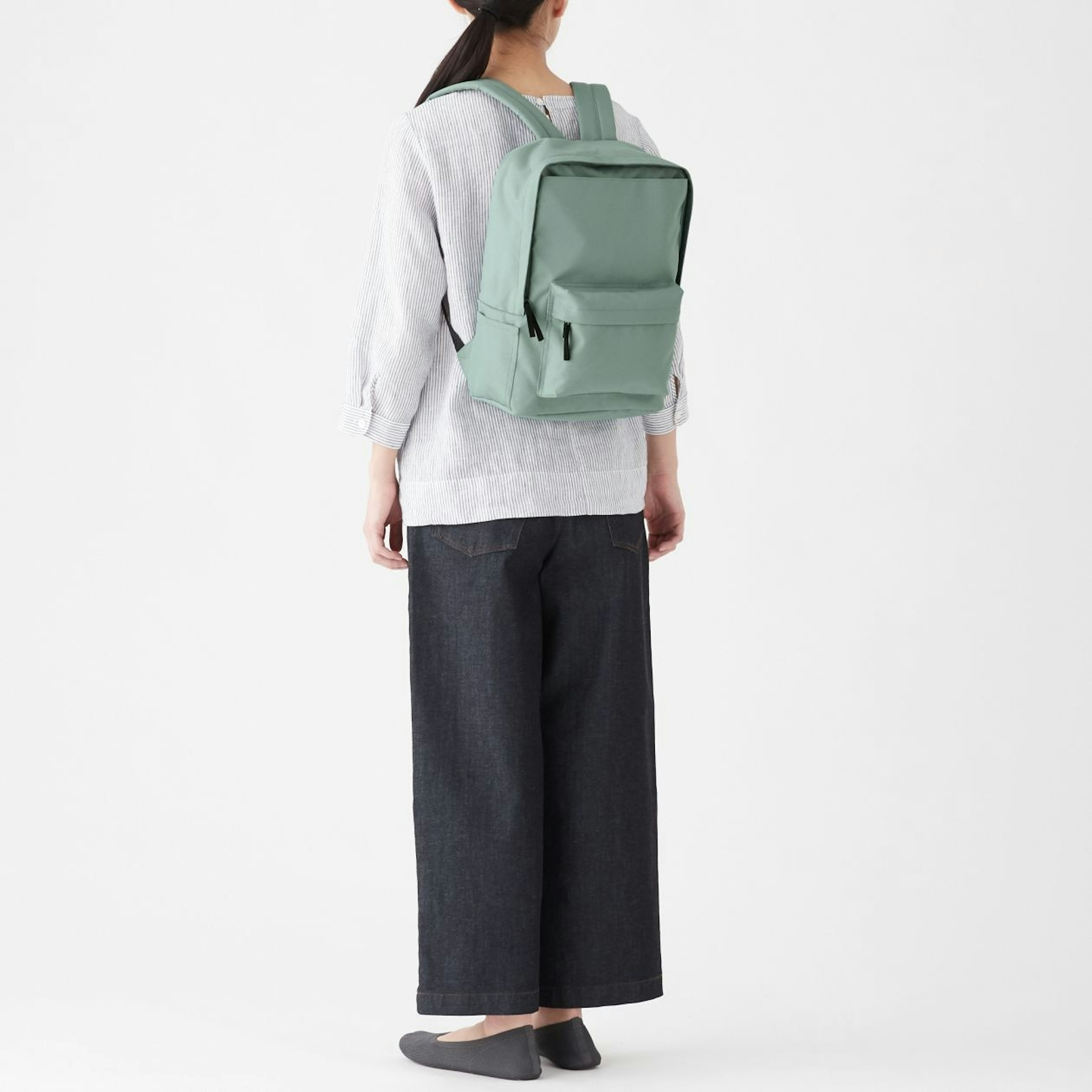 シンプルでおしゃれなデザインのリュックを背負う女性
