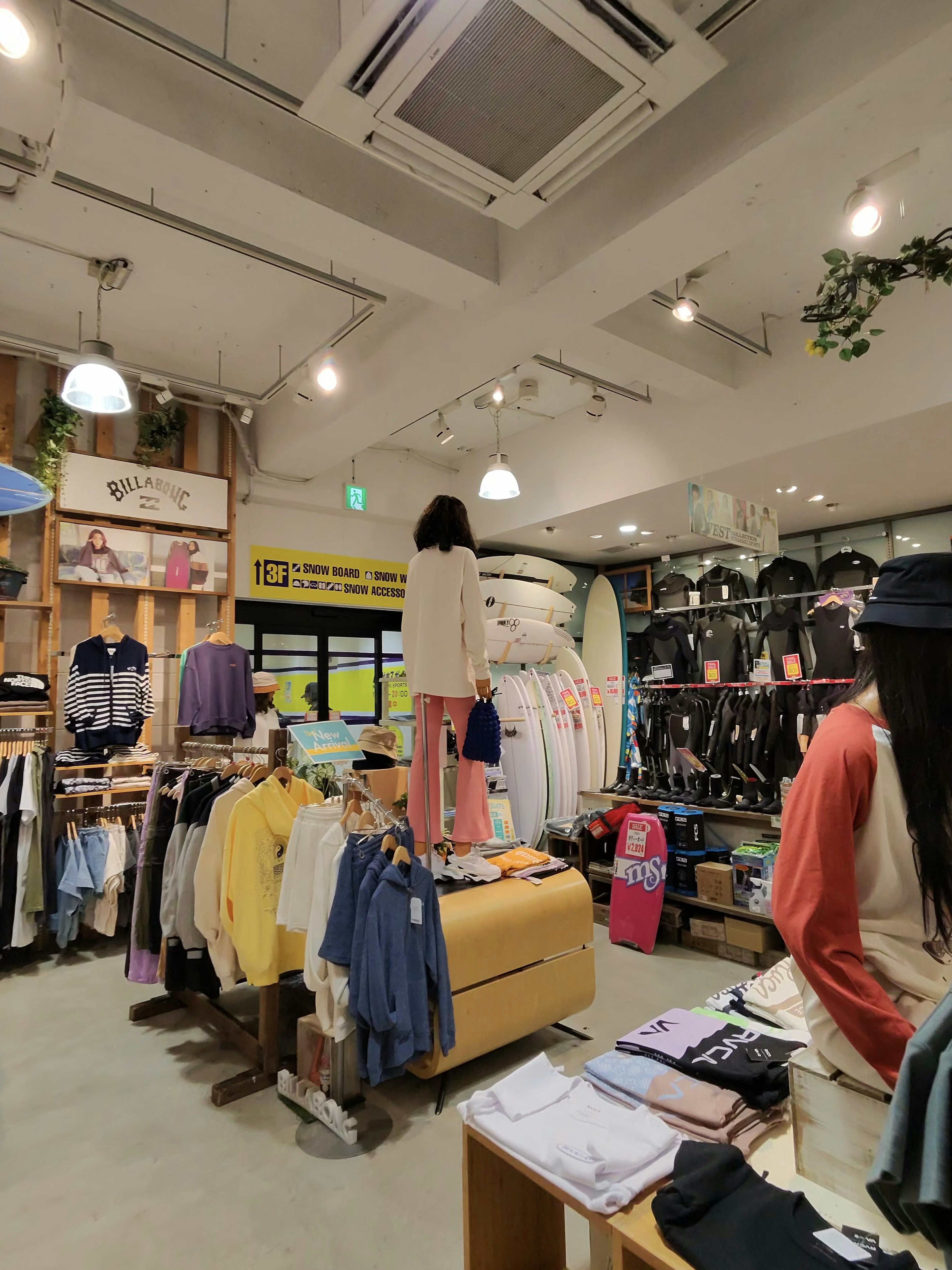 ムラサキスポーツの店内の様子。店内には多様なカジュアルウェアとサーフボードが陳列されており、壁際にはウェットスーツが並んでいる