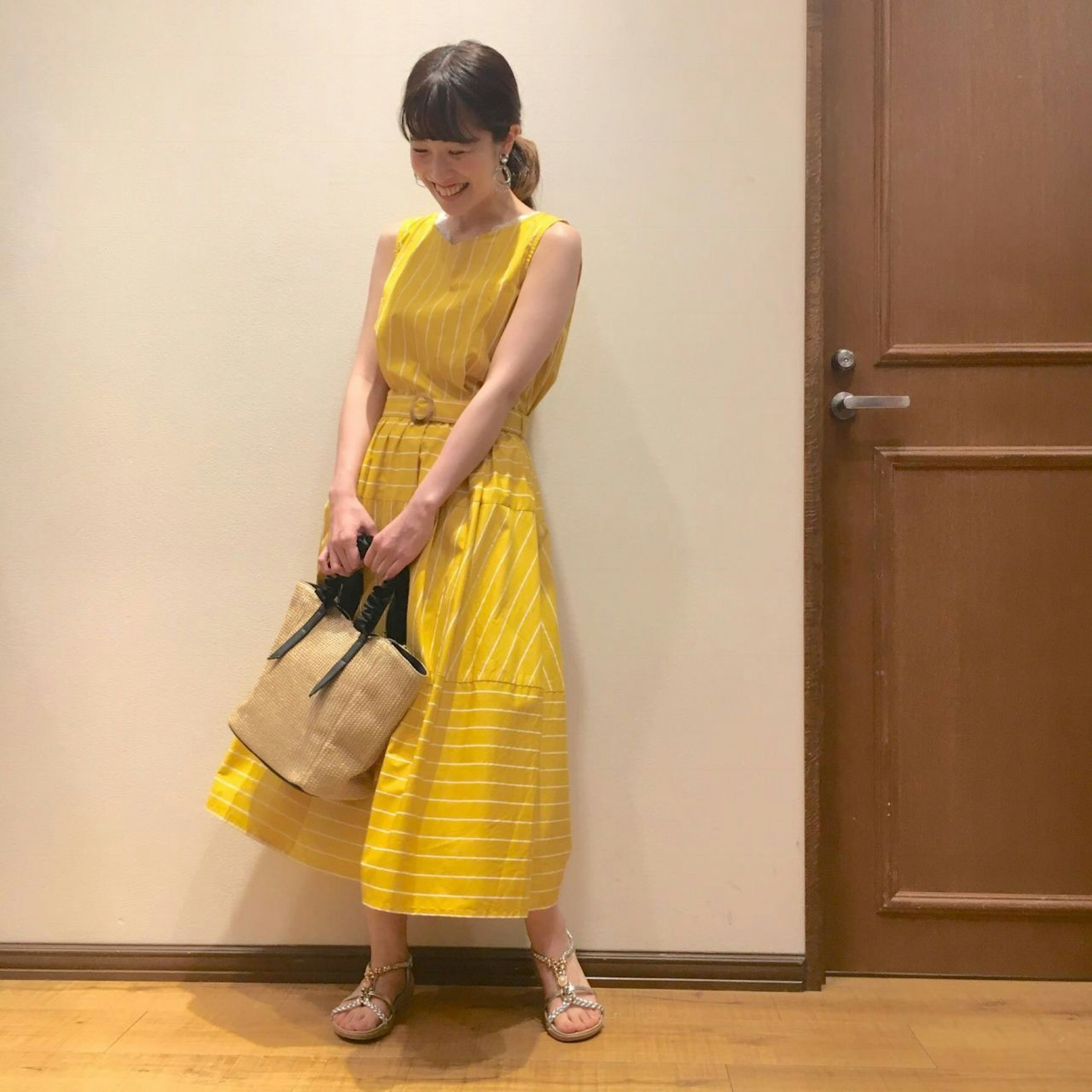明るい黄色のワンピースで夏のレディースファッションを楽しむ