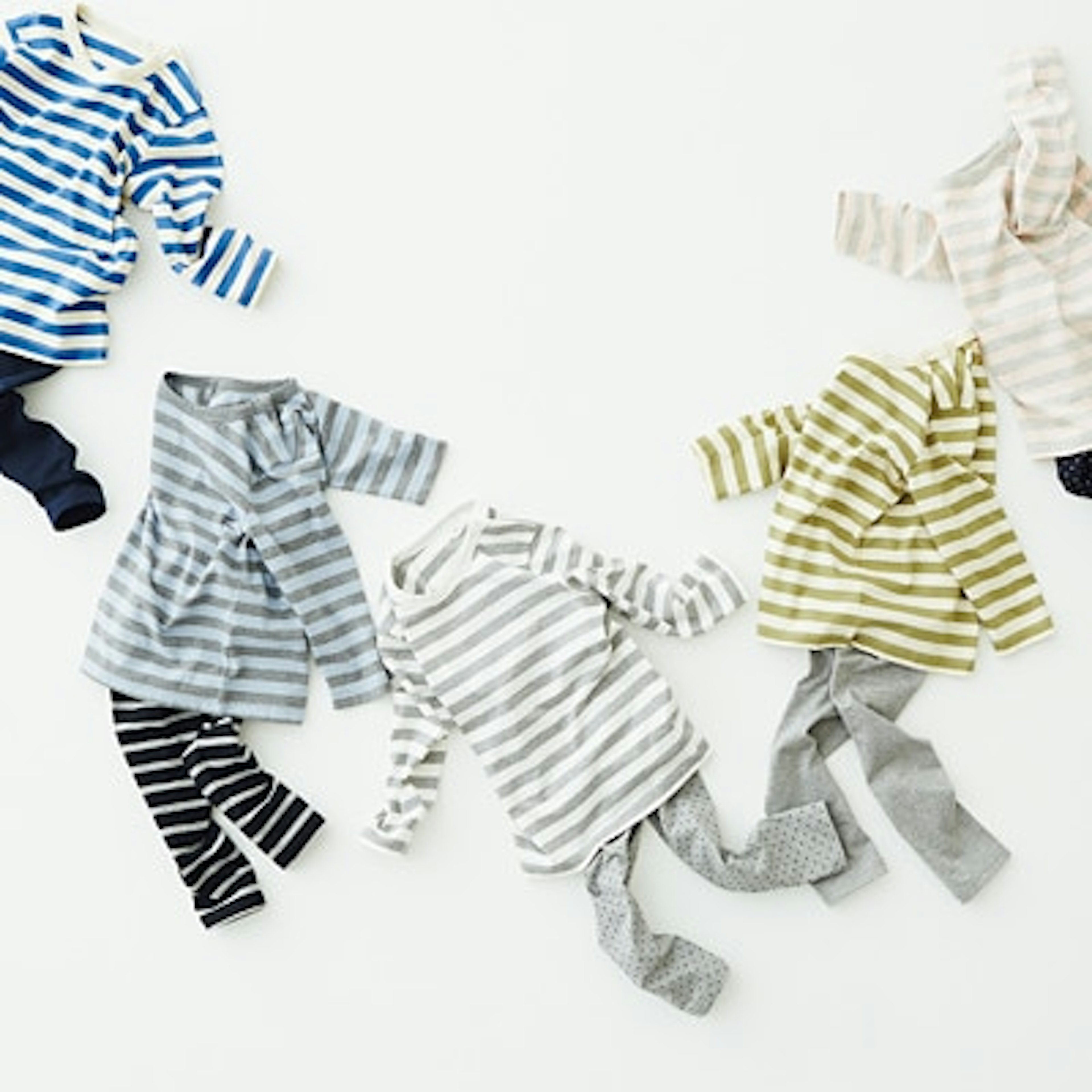 カラフルなボーダー柄の子供服セットが並ぶ