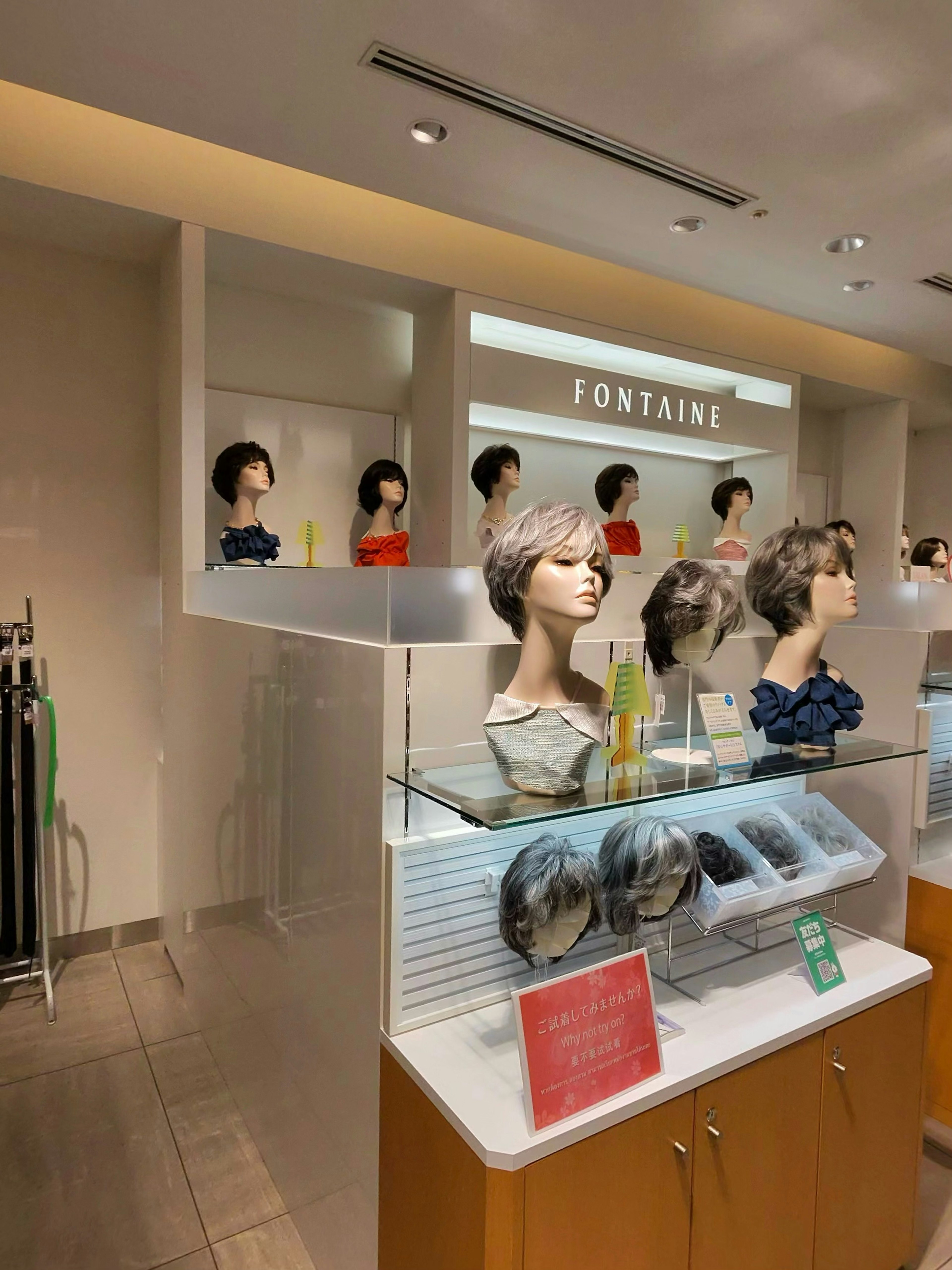 明るい婦人服フロアでフォンテーヌのウィッグとヘアケア商品を展示