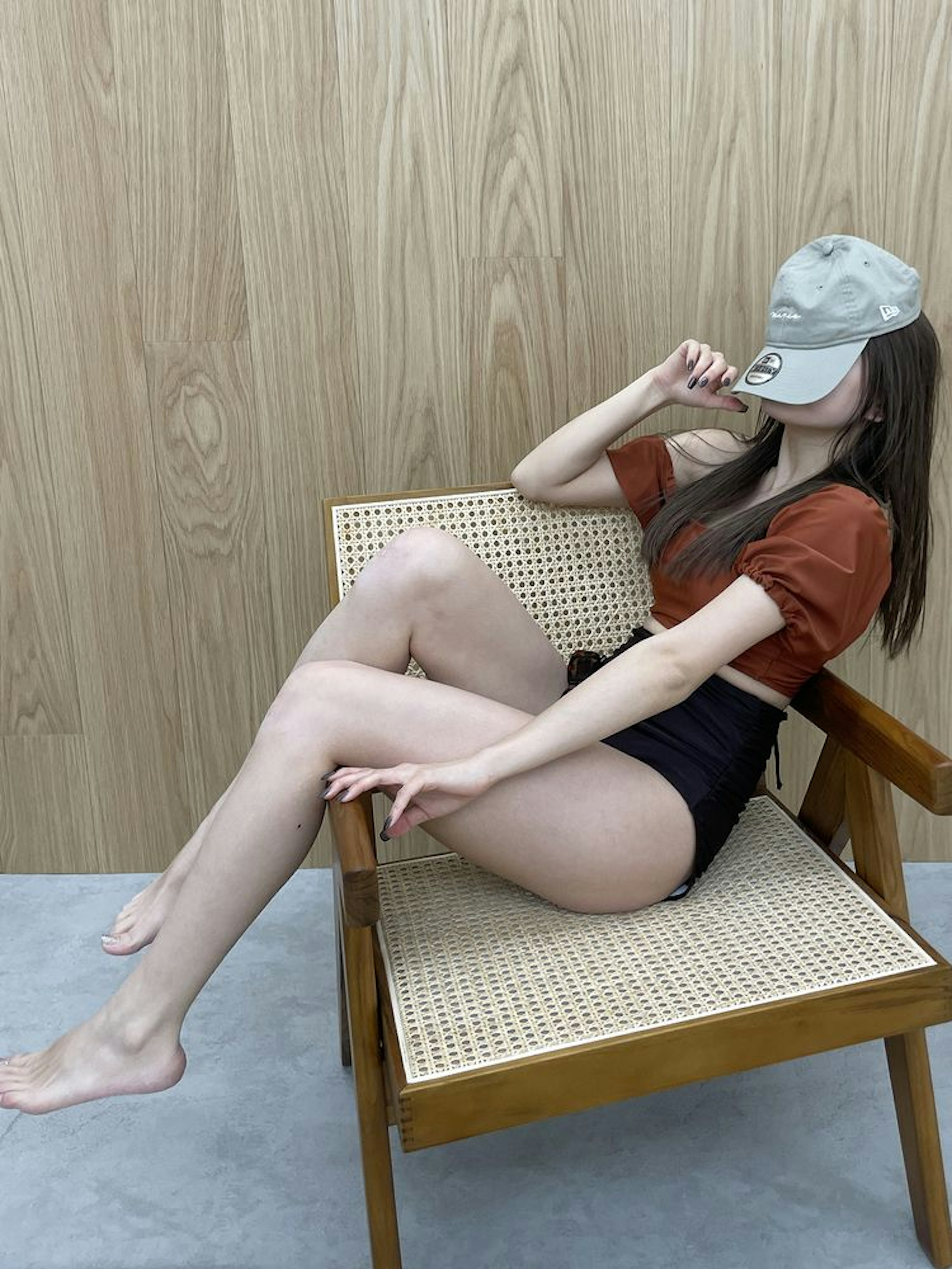 赤と黒のセットアップ水着を着た女性が椅子に座っている