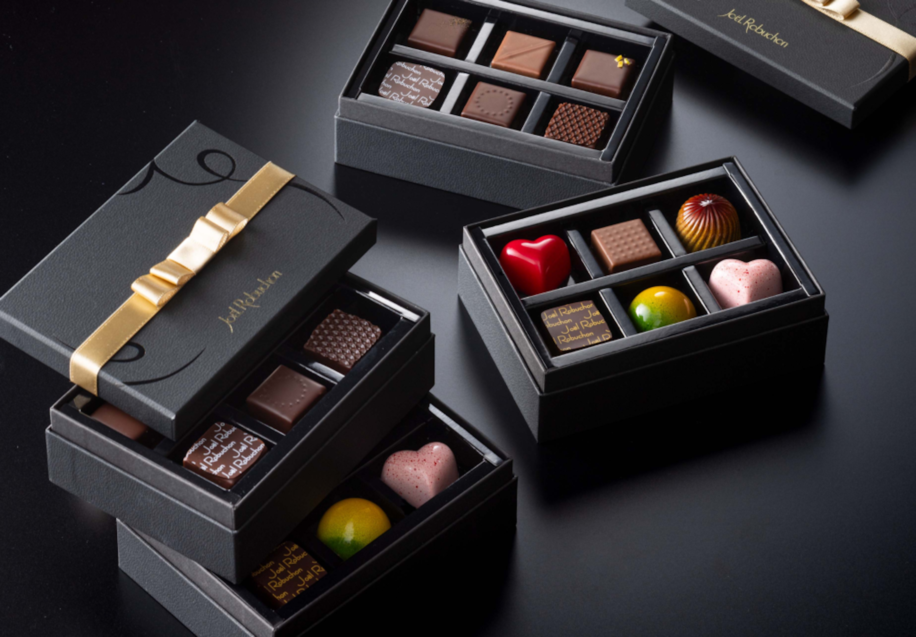 ラ ブティック ドゥ ジョエル ロブションのチョコレート。ゴールドのリボンがかかった黒い箱に入っている。