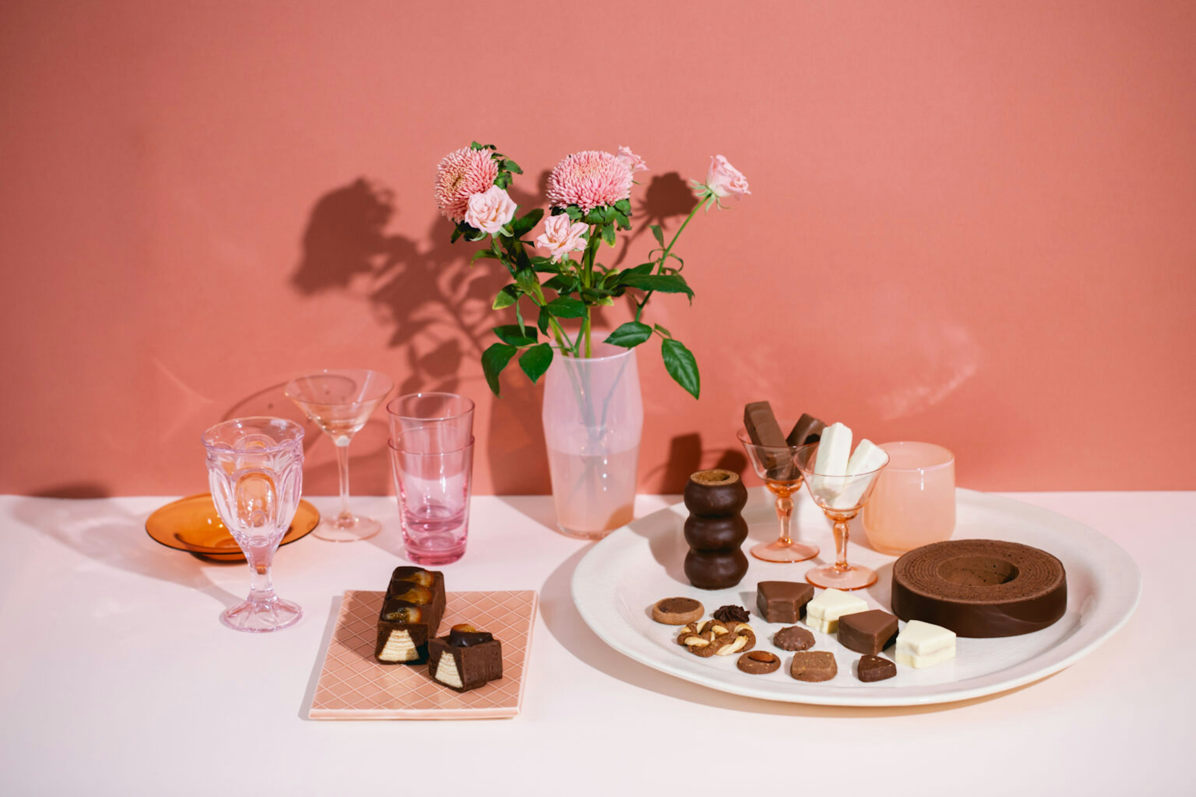 ピンクの花と並ぶ華やかなチョコレートスイーツ
