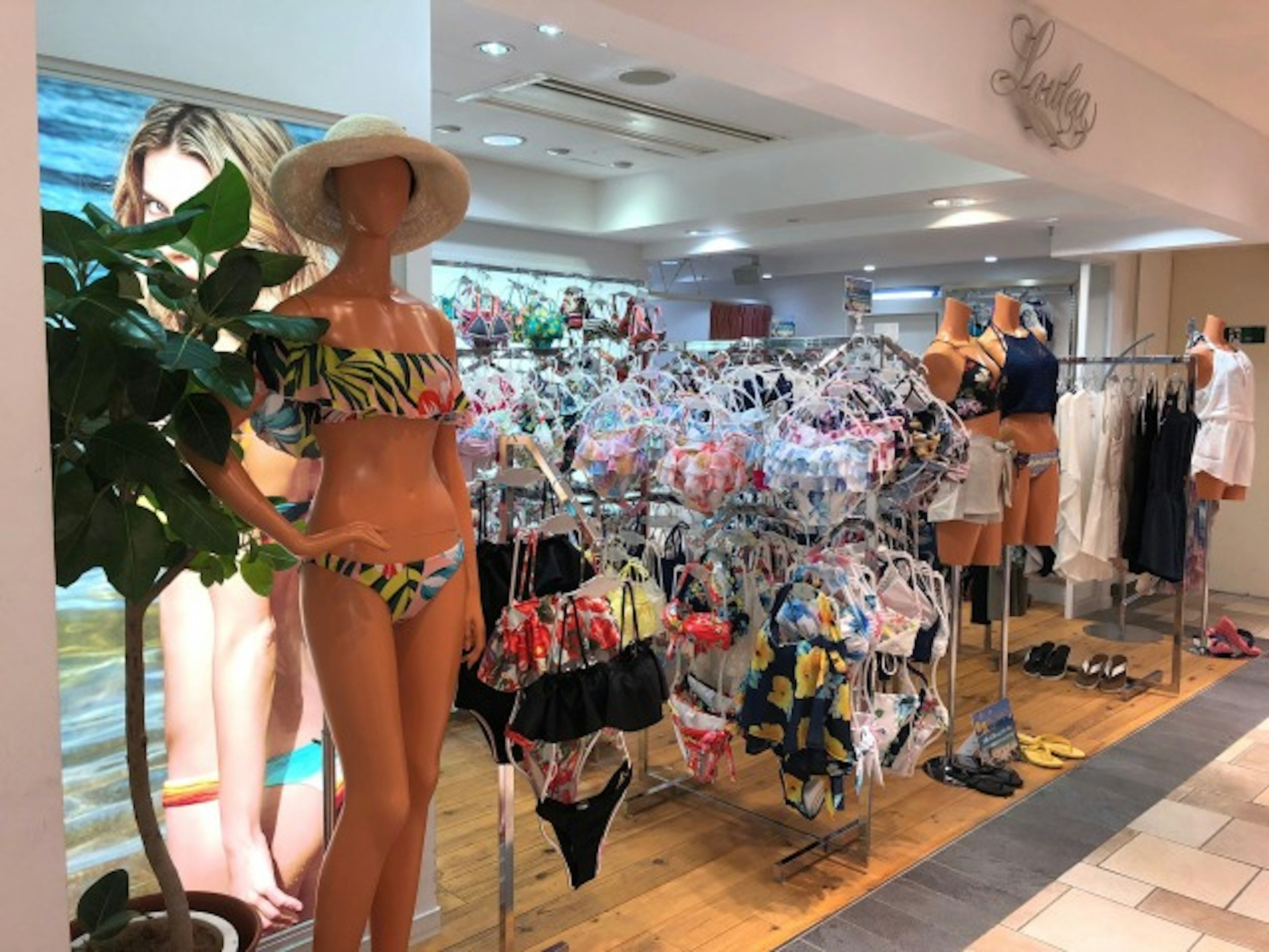 LAULEA梅田EST店の外からカラフルな水着がたくさん見えている様子